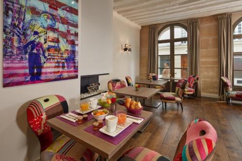 une salle à manger avec une table et des chaises dans l'établissement Hôtel de Notre-Dame, à Paris