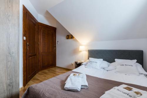 a bedroom with a bed with two towels on it at Willa Baciarka-basen, sauny i jacuzzi in Kościelisko