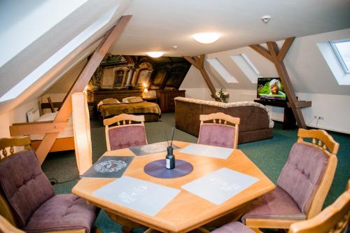 a living room with a wooden table and chairs at Hotel Polonia - Frankfurt/Oder in Frankfurt/Oder