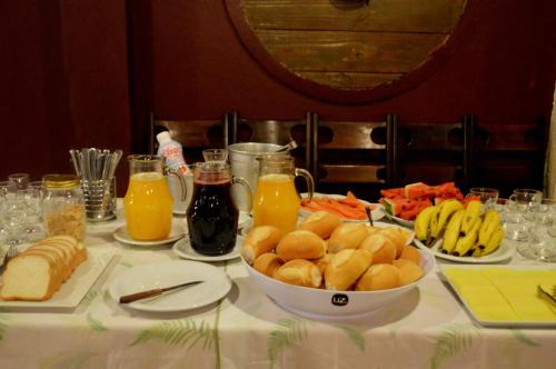 a table with a bowl of bread and orange juice at Hotel Glória in São Gabriel