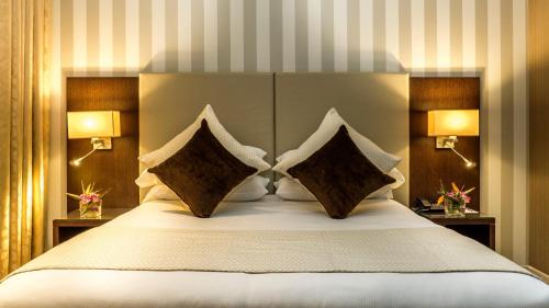 a bedroom with a large white bed with two pillows at AZ Hôtels Zeralda in Zeralda
