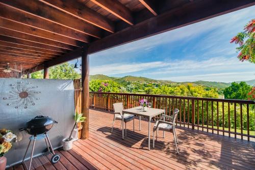 a deck with a table and chairs and a grill at Stellata - inverter for guests' comfort in Knysna