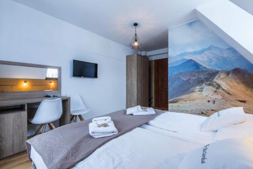 a bedroom with a large bed with towels on it at Willa Baciarka-basen, sauny i jacuzzi in Kościelisko