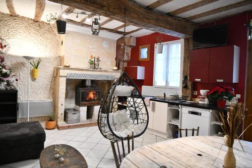uma cozinha e sala de estar com lareira e mesa em Les Gîtes des Châteaux, gîtes troglodytiques em Bourré