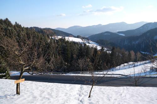 a snow covered hill with a road and mountains at Apartment Jorsi with Mountain View in Zreče