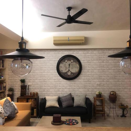 a living room with a clock on a brick wall at Home In Tainan in Tainan