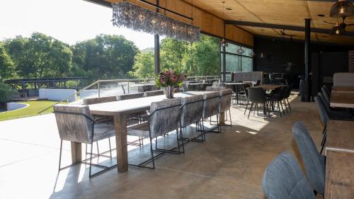 a dining room with a long table and chairs at Cradle Boutique Hotel in Lanseria