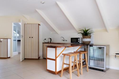 a kitchen with a counter and some stools at Laurel Cottage in Franschhoek