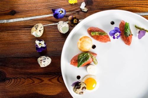 a plate of food with eggs and flowers on a table at Hotel Restaurant Kirchsteiger in Vollan