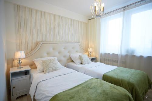 una camera con due letti e un lampadario a braccio di APARTAMENT IZABEL a Varsavia