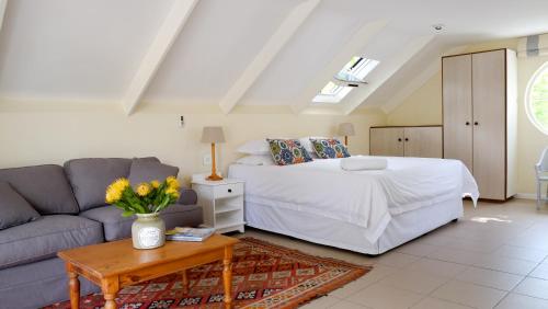 un soggiorno con letto e divano di Laurel Cottage a Franschhoek