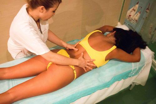 a woman in a yellow bikini laying on a hospital bed at Hotel Dreams Beach in Hammam Sousse