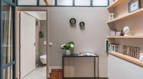un couloir avec une table en verre et des toilettes dans l'établissement Résidence Bastille Liberté, à Paris