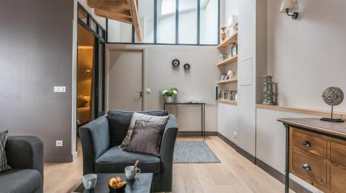 un salon avec un canapé et une chaise dans l'établissement Résidence Bastille Liberté, à Paris