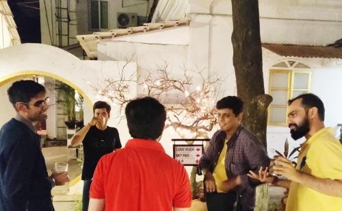 a group of men standing outside of a building at Bedrock Boutique Hostel in Baga