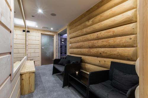 a living room with a wooden wall at Willa Baciarka-basen, sauny i jacuzzi in Kościelisko