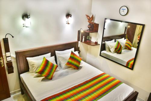 a bedroom with a bed and a large mirror at Villa Hikka 08 in Hikkaduwa