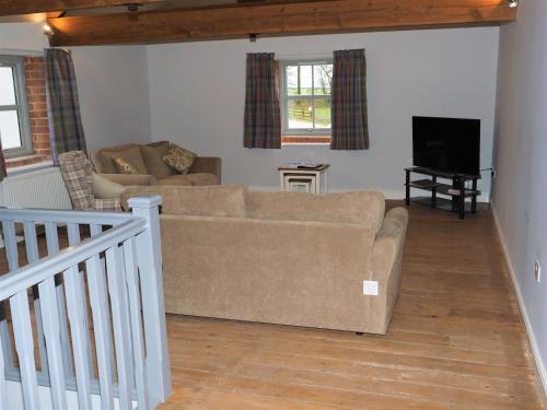 a living room with a couch and a tv at Nellies Shed, Wolds Way Holiday Cottages, 3 bed spacious cottage in Cottingham