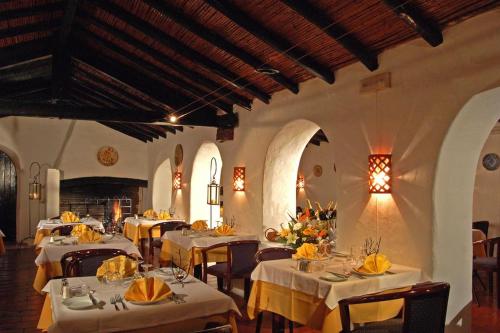 a restaurant with white tables and chairs with yellow napkins at Villa Pedras D'el Rei in Tavira