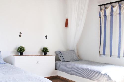 a bedroom with two beds and a window at Villa Pedras D'el Rei in Tavira