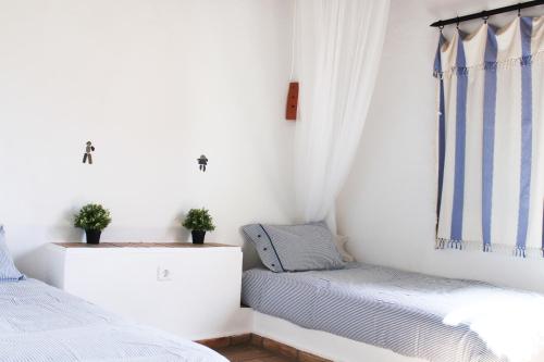 una camera da letto con due letti e una finestra di Villa Pedras D'el Rei a Tavira