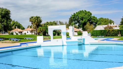 a pool at a resort with a water slide at Villa Pedras D'el Rei in Tavira
