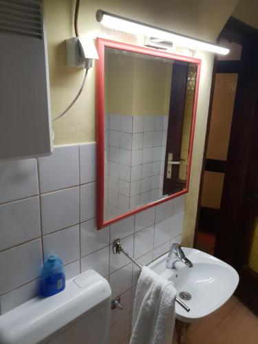 ein Badezimmer mit einem Waschbecken, einem Spiegel und einem WC in der Unterkunft Svjetlost in Jahorina