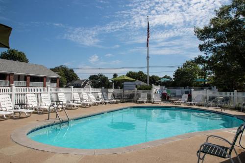 una piscina con sillas y una bandera americana en Sea View Motel, en Ogunquit