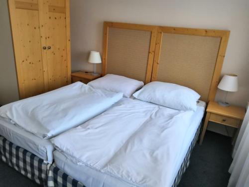 a bedroom with a bed with white sheets and pillows at Penzion u lípy in Jestřebí