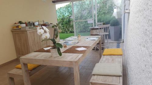 a wooden table in a kitchen with a table with flowers at B&B Vivere il Mare in Numana