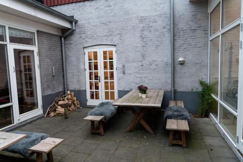 a patio with a wooden table and two benches at Vilcon Hotel & Konferencegaard in Slagelse
