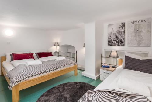 two beds in a room with green floors and white walls at Molo Longo apartments in Rijeka