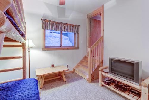a bedroom with a bed and a tv and a staircase at Contemporary ADK 5 Bedroom Chalet on Schroon in Schroon Lake