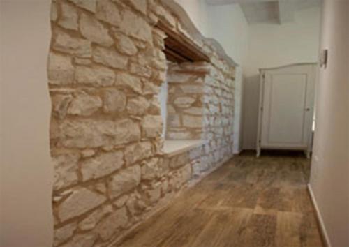 a room with a stone wall and a wooden floor at B&B Vivere il Mare in Numana