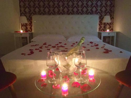 a bedroom with a bed with candles and wine glasses at Dimora San Biagio Suites&Apartment in Lecce