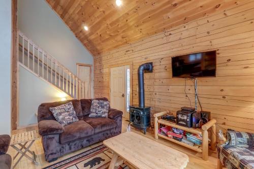 a living room with a couch and a tv and a table at Contemporary ADK 5 Bedroom Chalet on Schroon in Schroon Lake