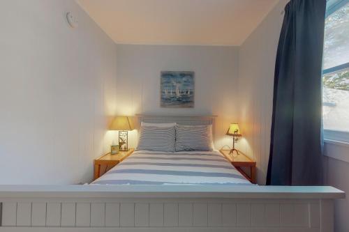 a bedroom with a bed with two lamps and a window at Toddy Pond Jack in Orland