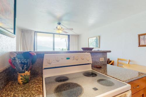 a kitchen with a stove top oven in a kitchen at Maalaea Banyans 105 in Wailuku