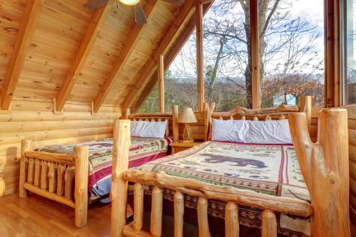 two beds in a log cabin bedroom with a large window at Kodiak #45 in Sevierville