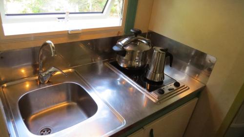 a kitchen sink with a coffee pot on a stove at Bungalows Bahia de la Plata in Zahara de los Atunes