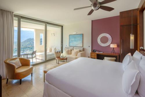 a bedroom with a large bed and a living room at Jumeirah Mallorca in Port de Soller