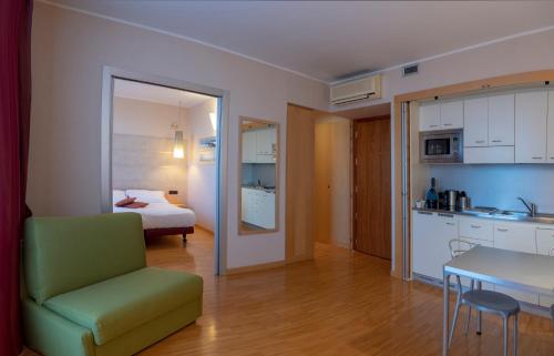 ein Zimmer mit einer Küche und ein Schlafzimmer mit einem Bett in der Unterkunft AlbaResidence Masera26 in Alba