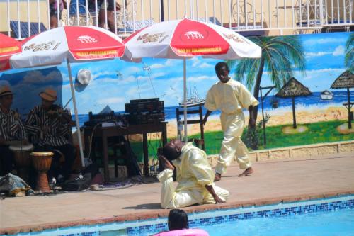 a couple of people standing next to a swimming pool at Hôtel - Appartement meublé " LES FLOTS BLEU " in Antananarivo
