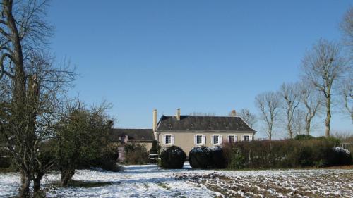 a house with two large tires in the snow at Le Petit Bois in Château-la-Vallière