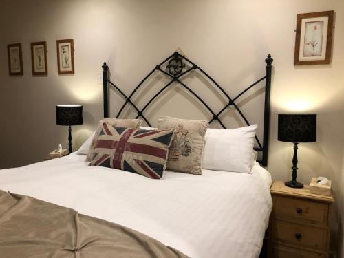 a bedroom with a bed with white sheets and pillows at Park Farm in Windsor