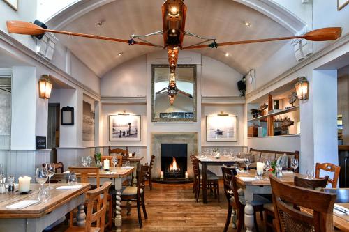 a restaurant with tables and chairs and a fireplace at The Bridge Pub & Rooms in London