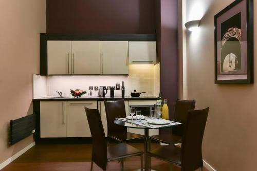 a kitchen with a table and chairs in a room at Fraser Suites Glasgow in Glasgow