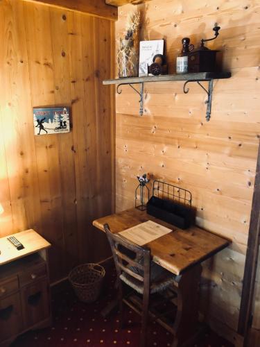 a wooden table in a room with a wooden wall at Le Coin Savoyard in Combloux