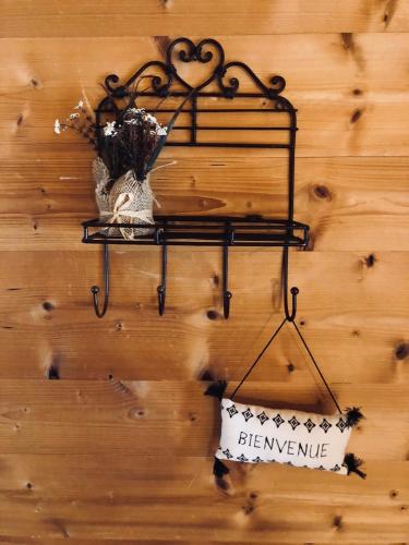 a black shelf with a sign on a wooden wall at Le Coin Savoyard in Combloux
