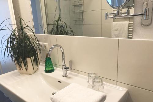 a bathroom sink with a faucet and a mirror at Art Apart Nomay Summercard Blick Top of Salzburg in Kaprun